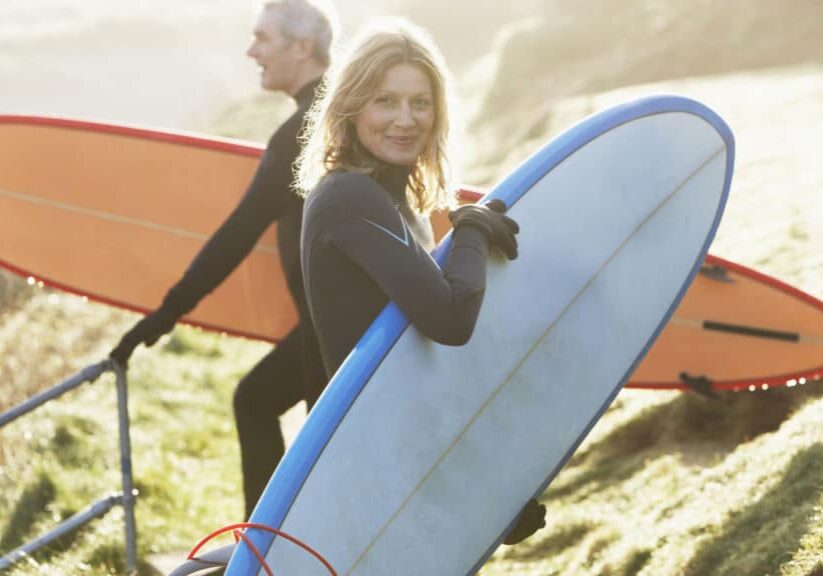 A man and a woman with surfboards
